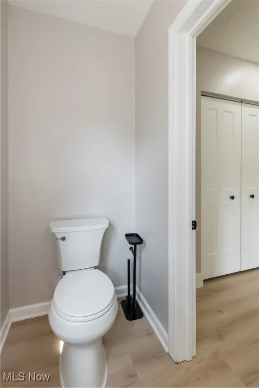 Bathroom with toilet and wood finished floors