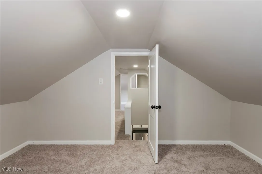 Additional living space featuring vaulted ceiling, carpet floors, and recessed lighting