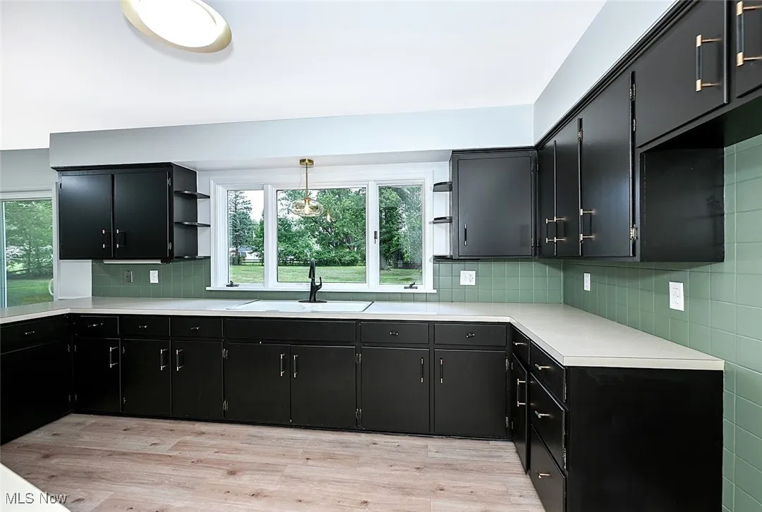 *KITCHEN W/BLACK CABINETS, BLACK/GOLD TEXTURED HARDWARE, PENINISULA W/DOUBLE SIDED CABINETS, ABOVE SINK PENDANT LIGHTING AND LUXURY PLANK FLOORING ~