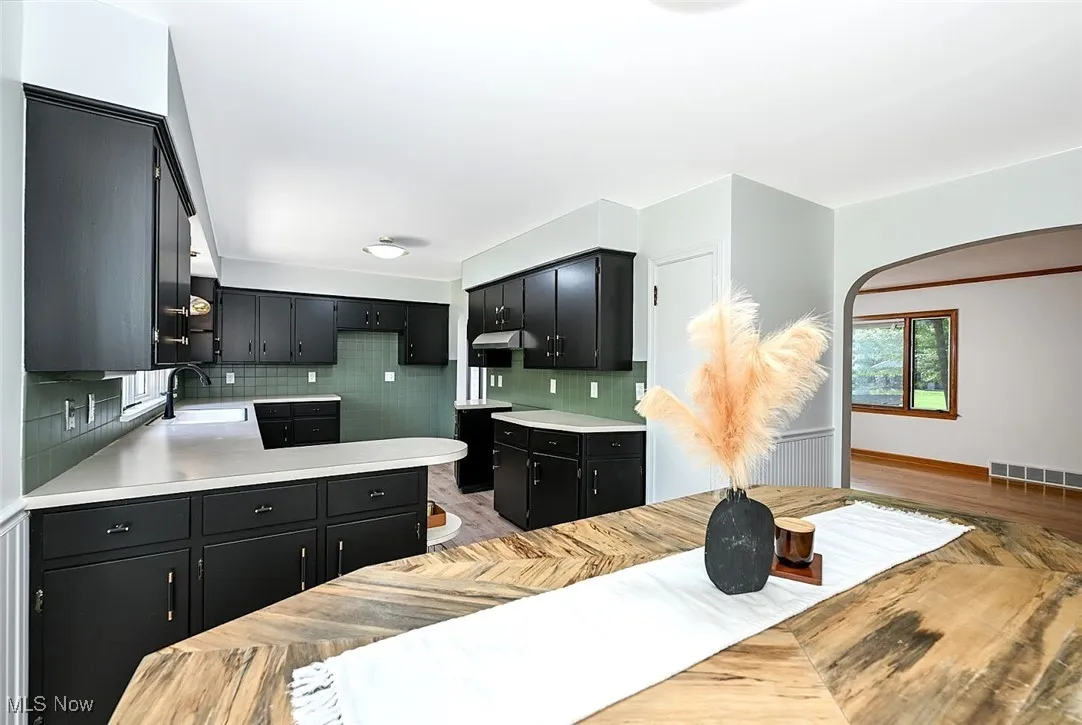*DINING AND KITCHEN W/BLACK CABINETS, BLACK/GOLD TEXTURED HARDWARE, PENINISULA W/DOUBLE SIDED CABINETS, ABOVE SINK PENDANT LIGHTING AND LUXURY PLANK FLOORING ~