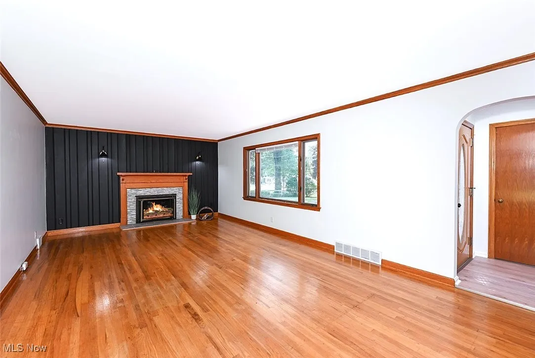 *LARGE LIVING ROOM W/SHINY HARDWOOD FLOORS, FEATURE WALL, CROWN MOLDING, STONE SURROUND FIREPLACE AND TILED HEARTH ~