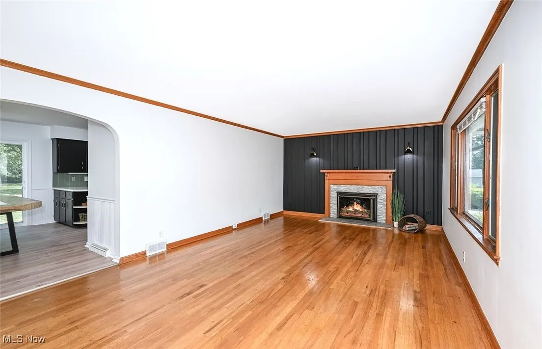 *LARGE LIVING ROOM W/SHINY HARDWOOD FLOORS, FEATURE WALL, CROWN MOLDING, STONE SURROUND FIREPLACE AND TILED HEARTH ~