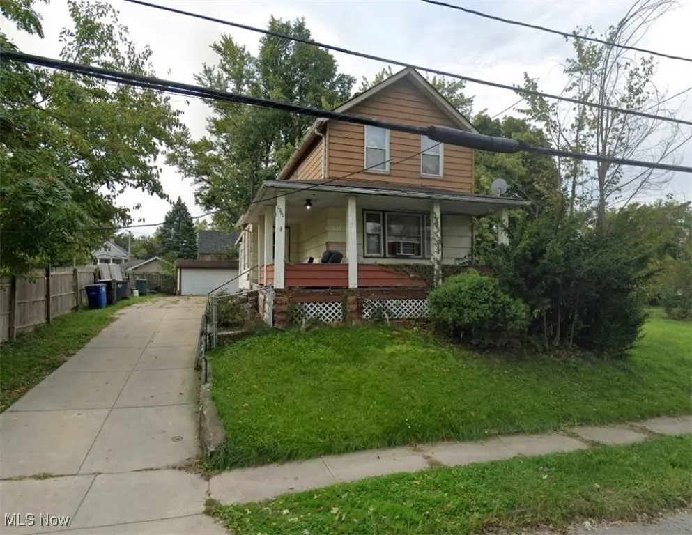 View of front of property featuring an outdoor structure, covered porch, and a garage