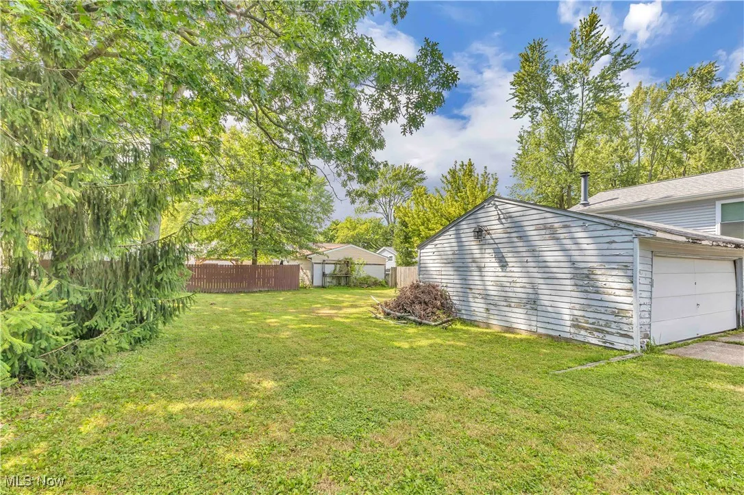 View of yard with a garage and view of wooded area