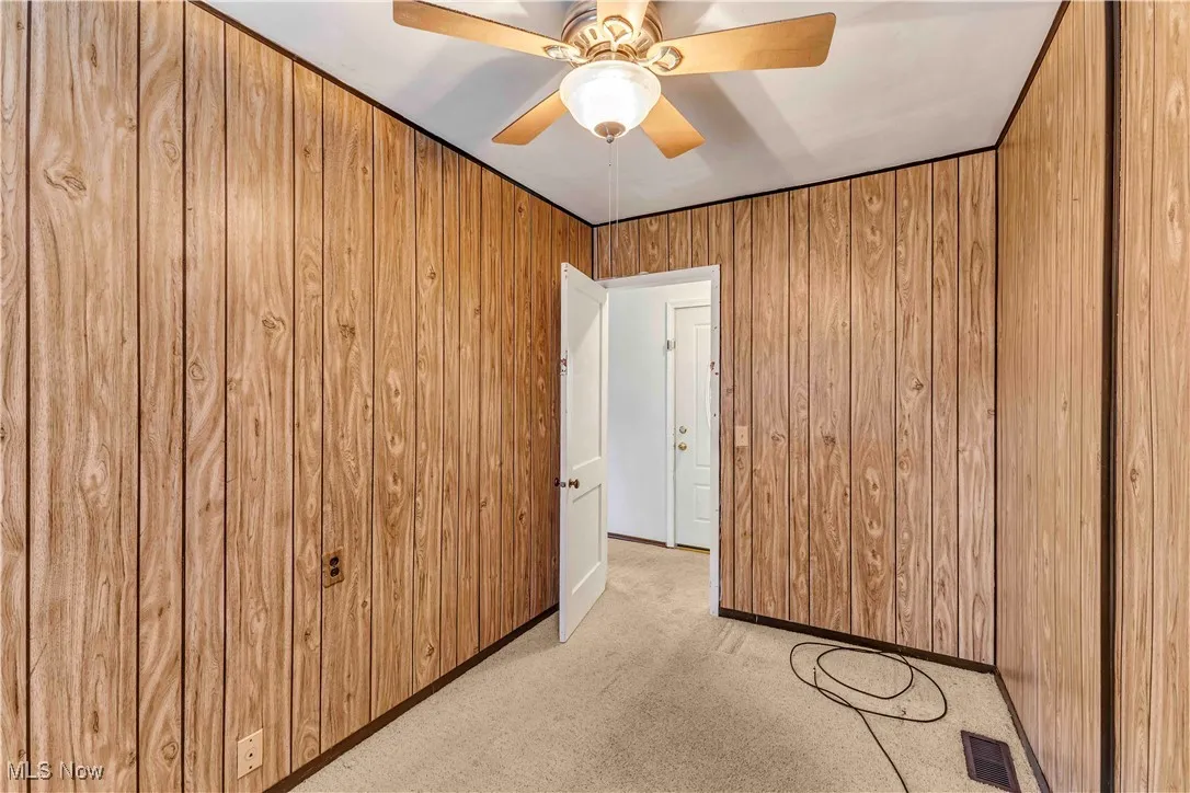 Empty room with light carpet and wooden walls