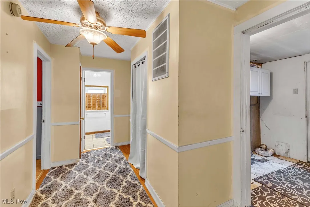 Hallway featuring light wood finished floors and a textured ceiling
