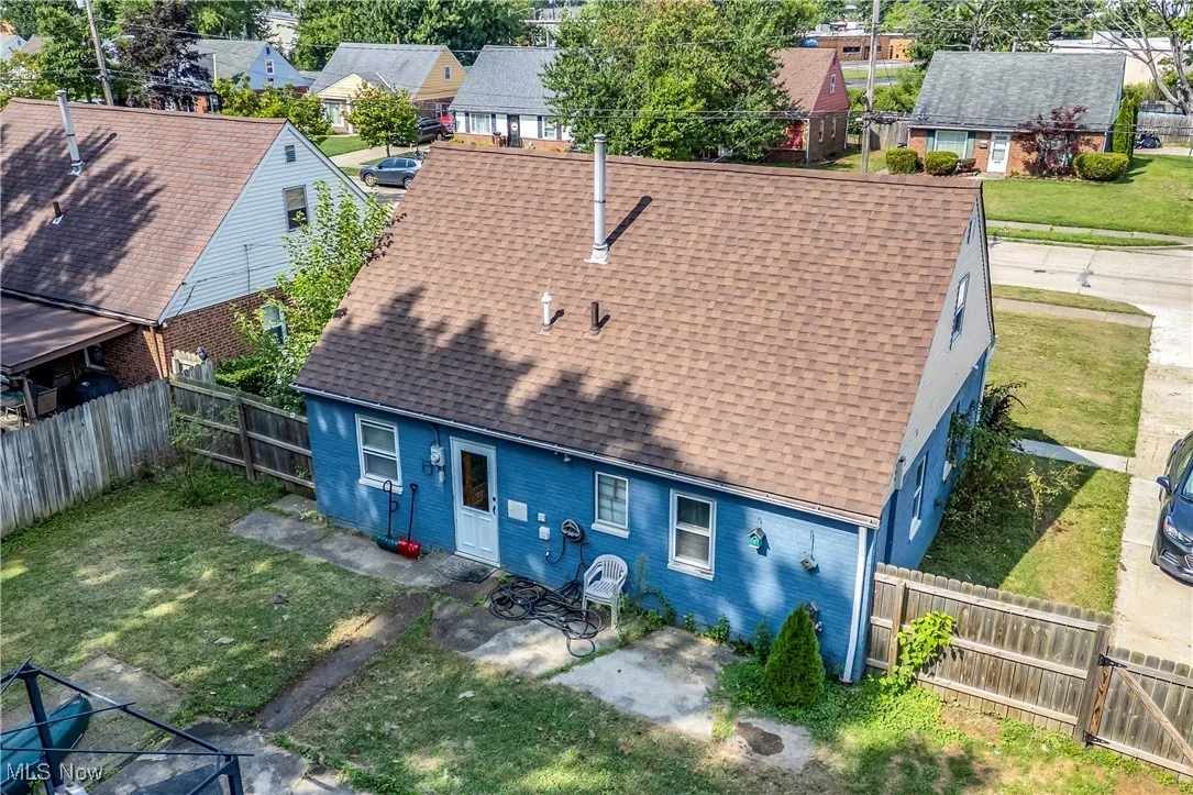 Rear view of house with roof with shingles, a patio, and brick siding