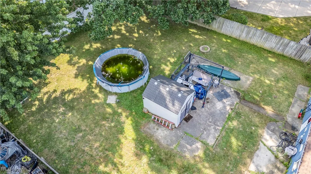 Back of house featuring a shingled roof, a patio, a fenced backyard, and a residential view