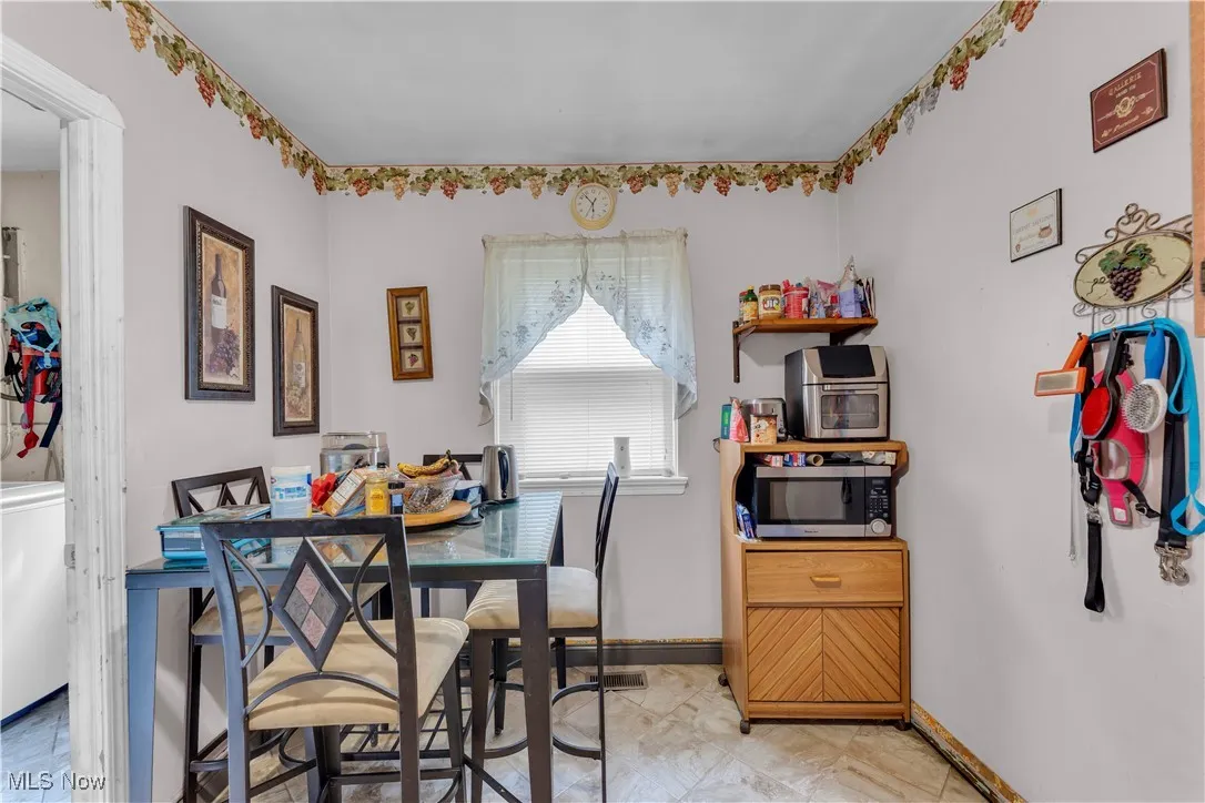 Kitchen featuring white appliances, dark brown cabinets, arched walkways, and gas water heater