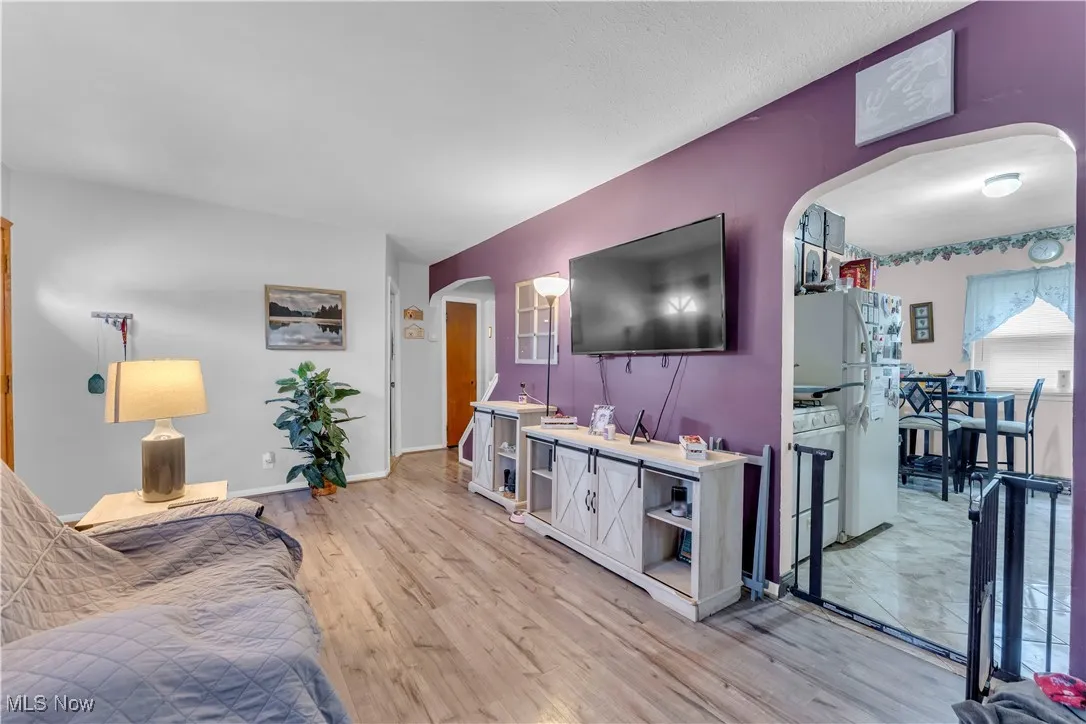 Kitchen featuring white appliances, washer / clothes dryer, arched walkways, gas water heater, and open floor plan