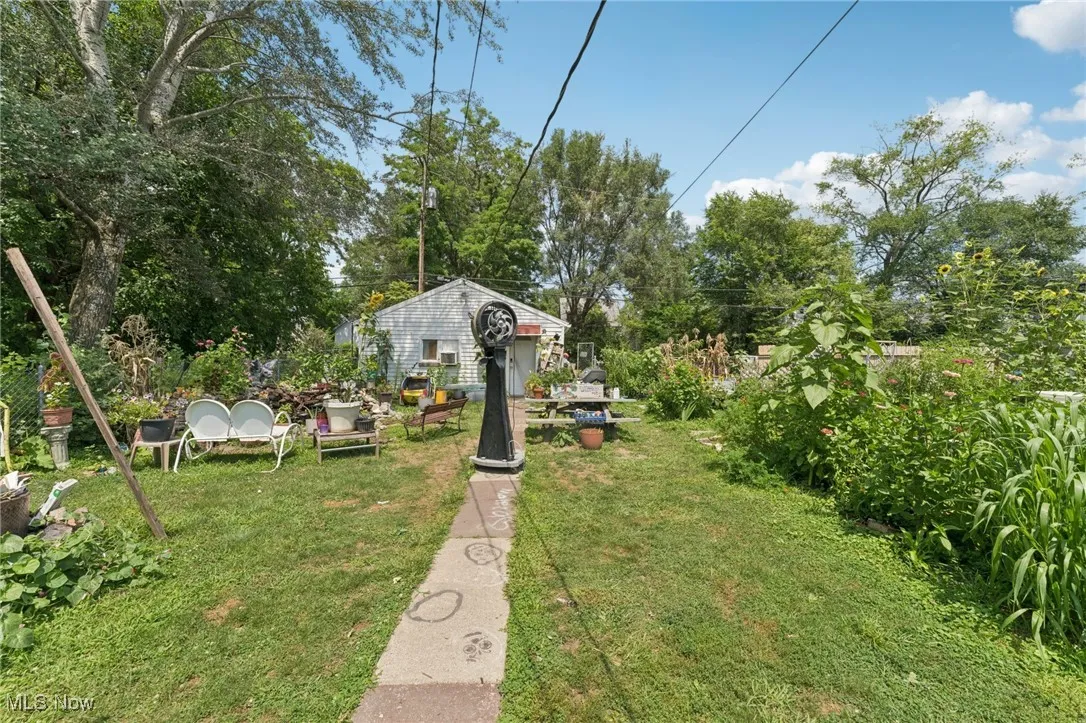 View of green lawn featuring view of wooded area