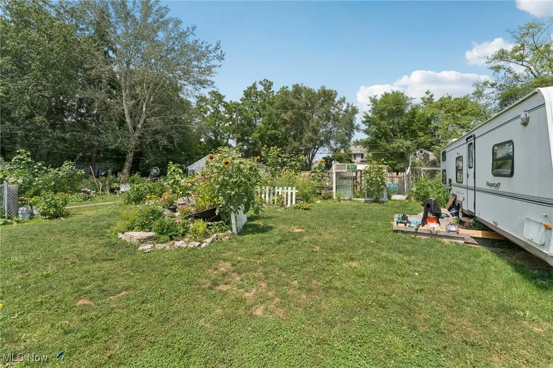 View of yard with view of wooded area and a garden