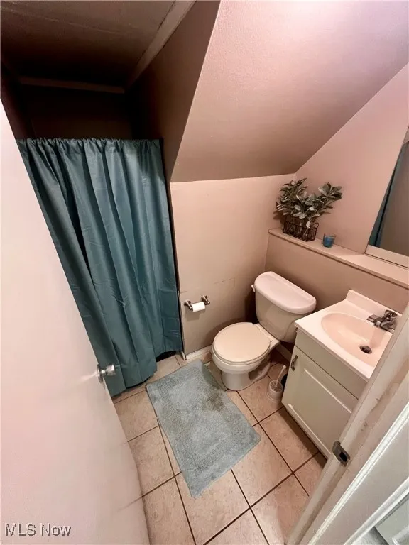 Full bathroom featuring tile patterned floors, vanity, a shower with curtain, and a textured ceiling