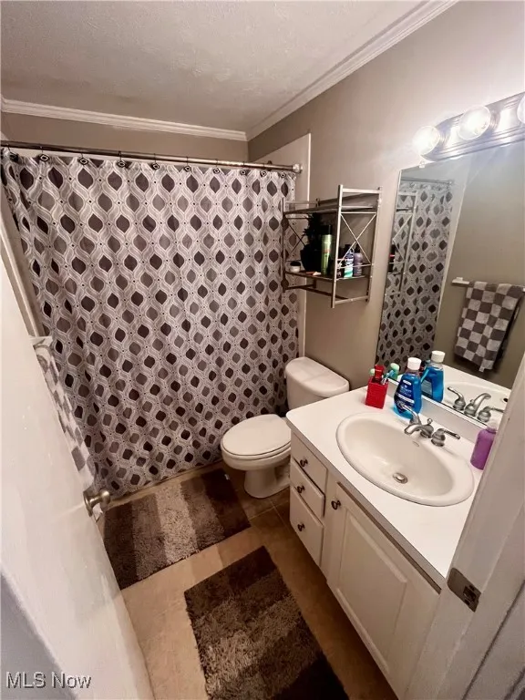 Bathroom with ornamental molding, a textured ceiling, vanity, tile patterned flooring, and a shower with shower curtain