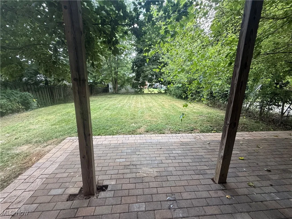fenced in backyard with patio