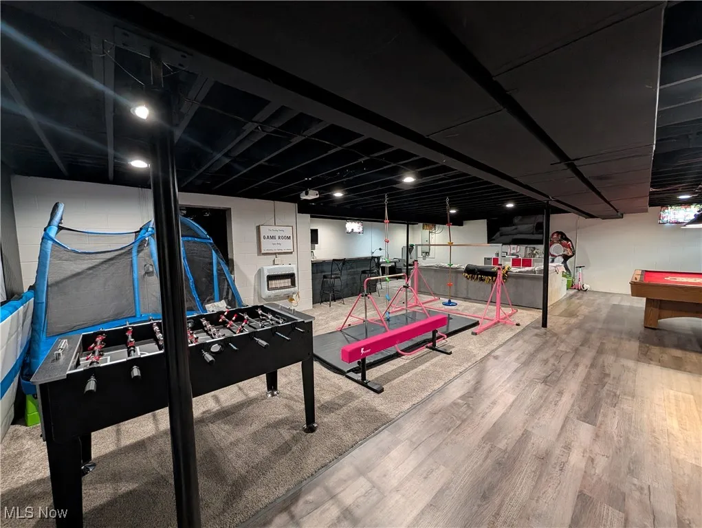 Rec room featuring billiards table, wood finished floors, and heating unit