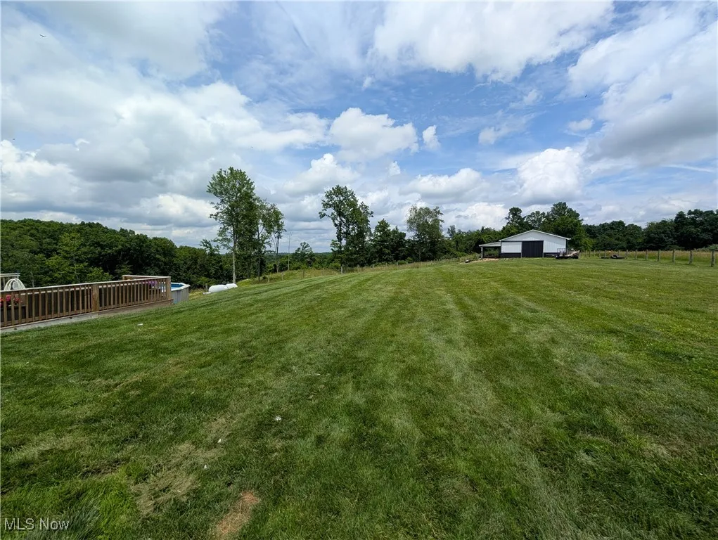 View of grassy yard featuring a view of rural / pastoral area and an outbuilding
