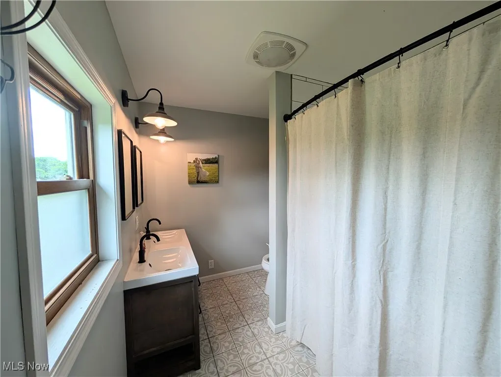Bathroom with vanity and a shower with shower curtain