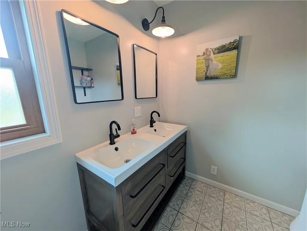 Bathroom with double vanity and tile patterned floors