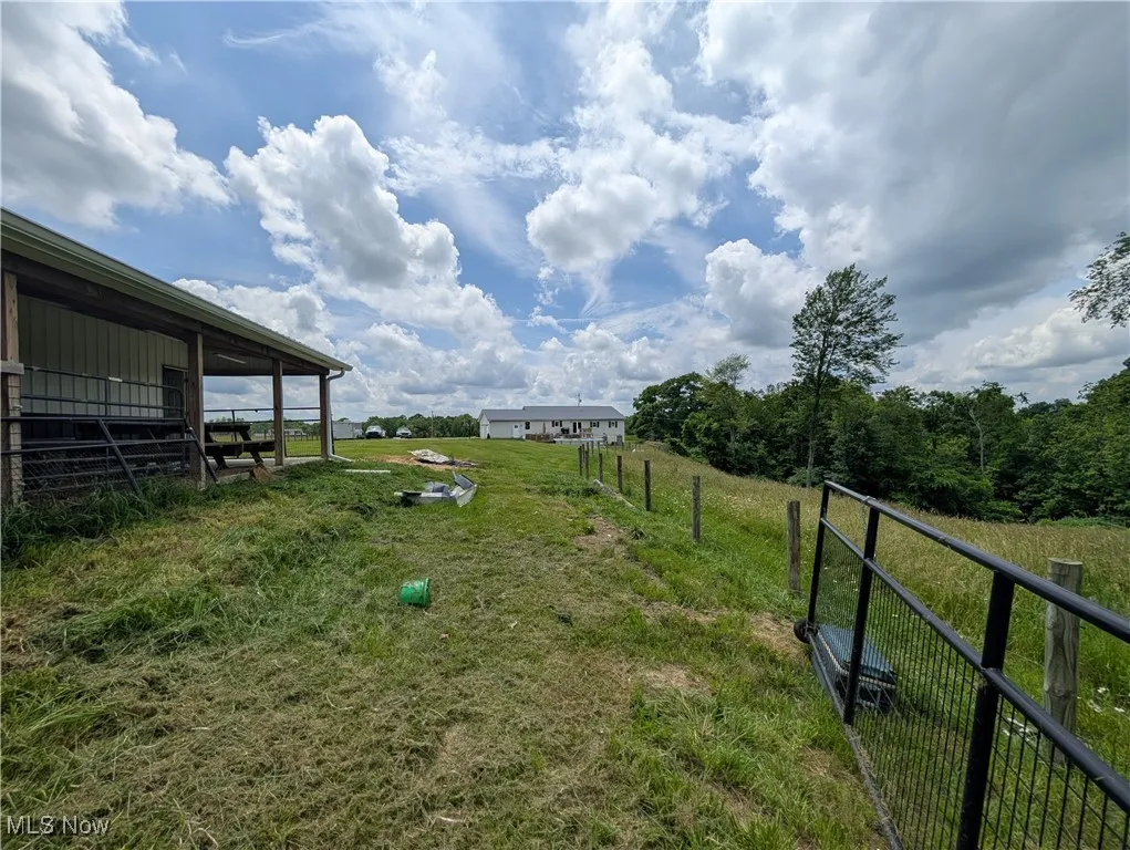 View of yard featuring a view of countryside, an outbuilding, and an exterior structure