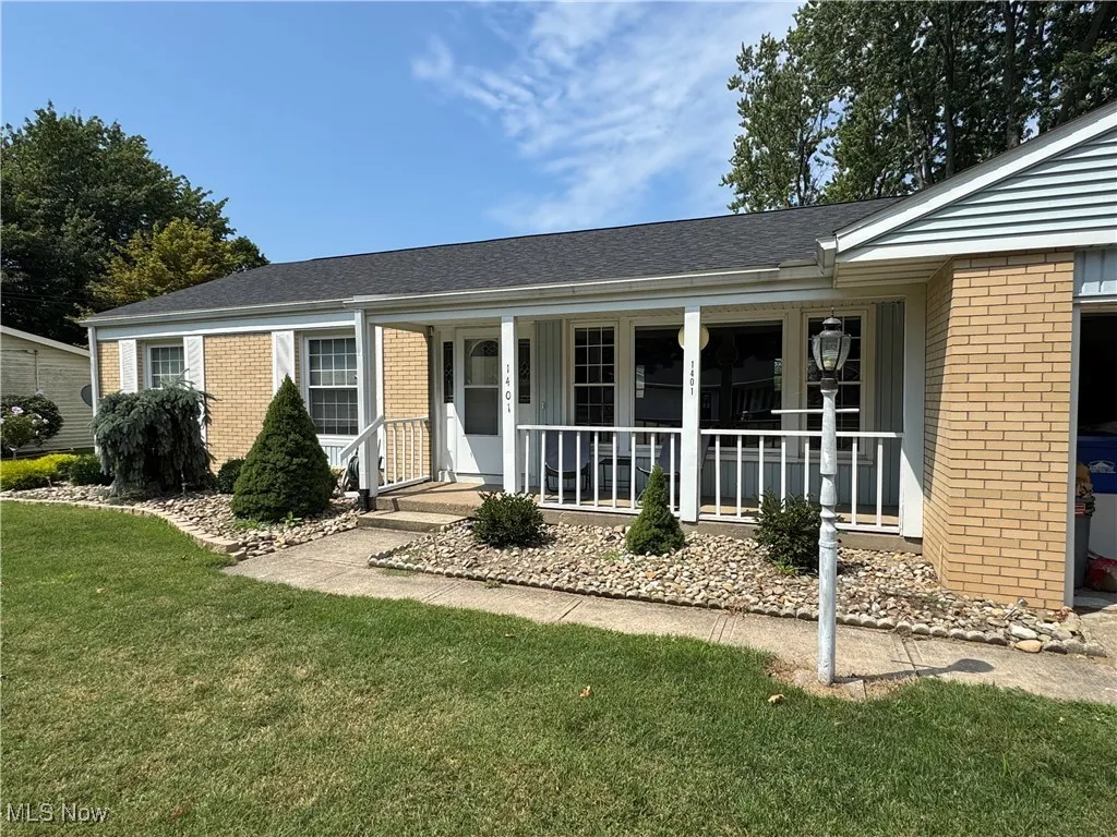 Ranch-style home with brick siding, a front yard, a shingled roof, and covered porch