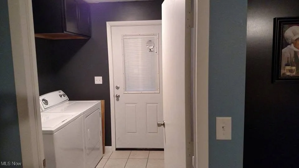 Laundry room featuring washer and dryer and light tile patterned floors