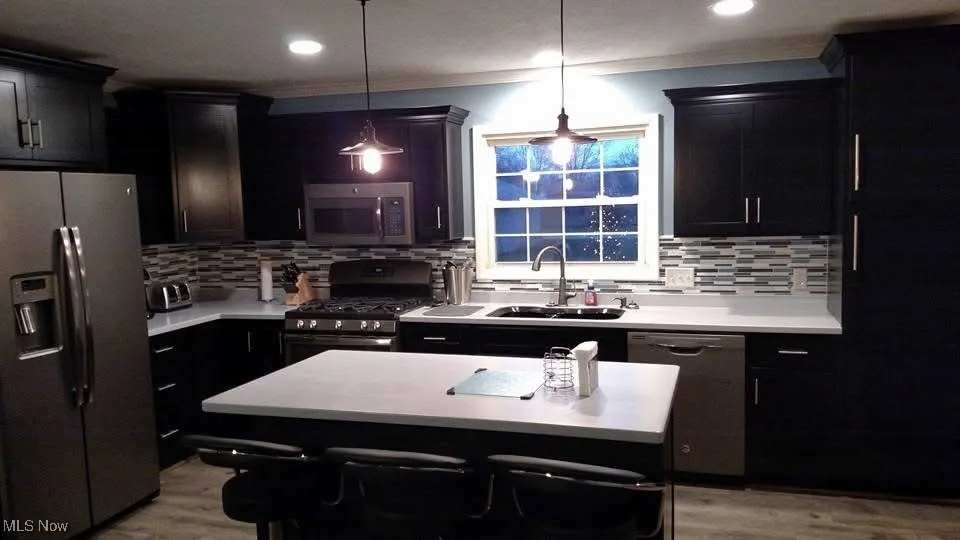 Kitchen featuring appliances with stainless steel finishes, light countertops, light wood-style flooring, and recessed lighting