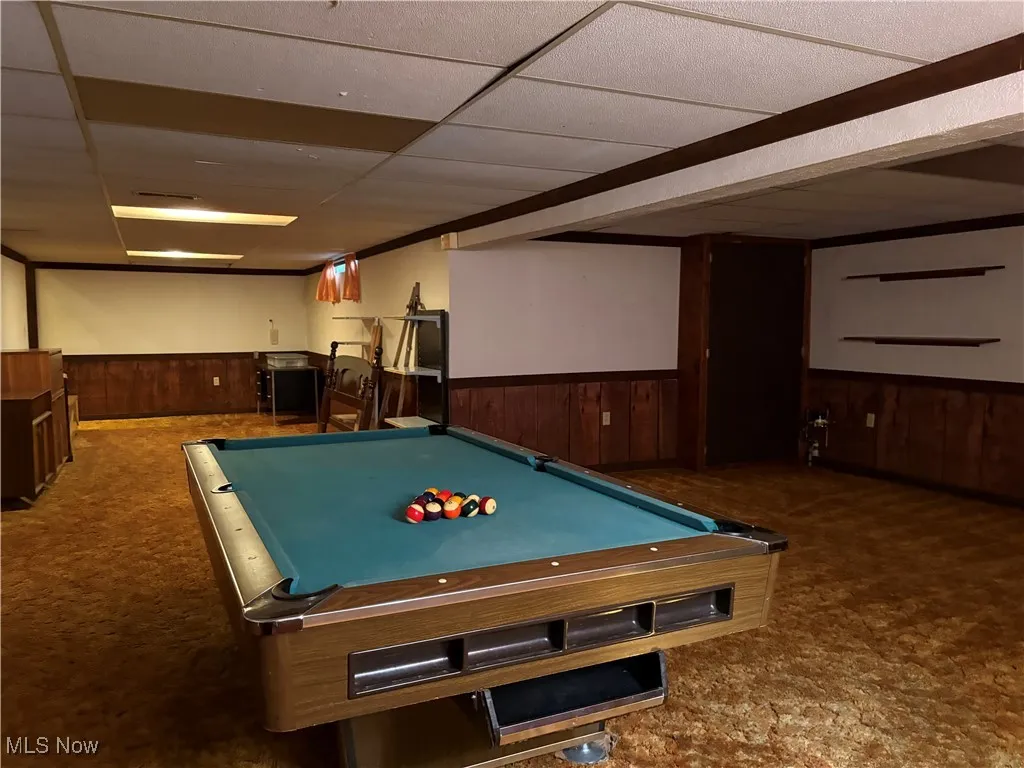 Playroom with a drop ceiling, billiards, carpet floors, wooden walls, and a wainscoted wall