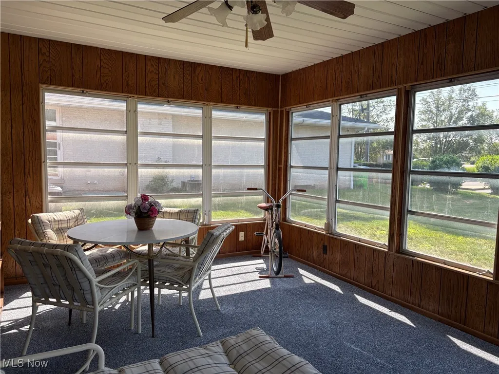 Sunroom / solarium with wooden walls and carpet floors