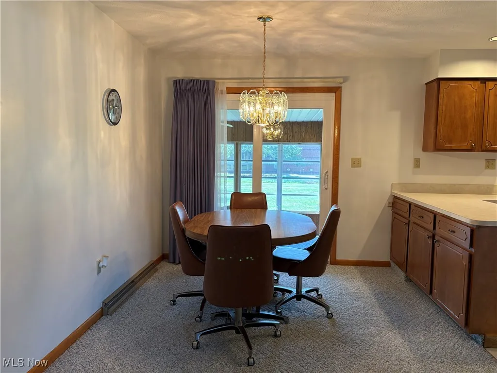 Dining space featuring light colored carpet and a chandelier