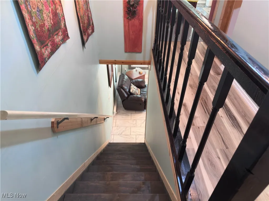 Staircase featuring baseboards and wood finished floors