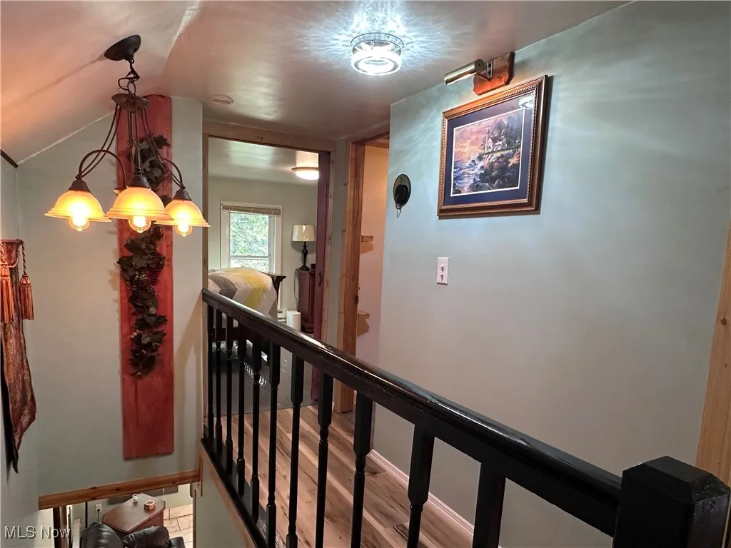 Hallway featuring an upstairs landing and wood finished floors