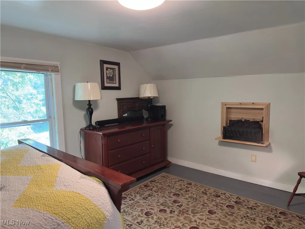 Bedroom with lofted ceiling and baseboards