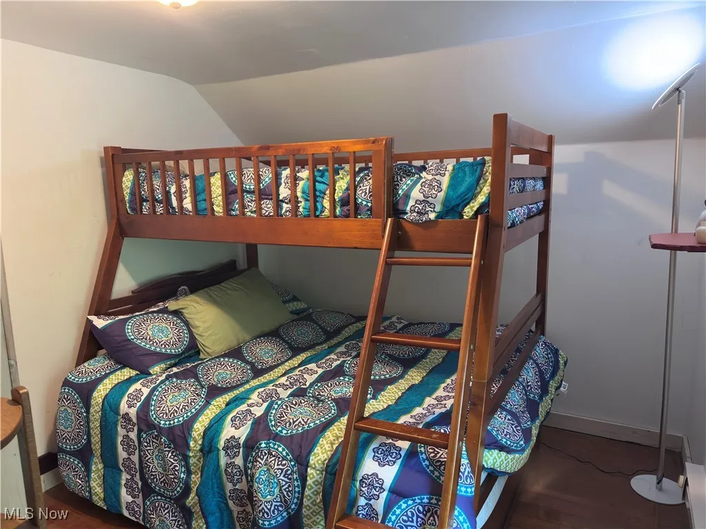 Bedroom featuring vaulted ceiling and baseboards