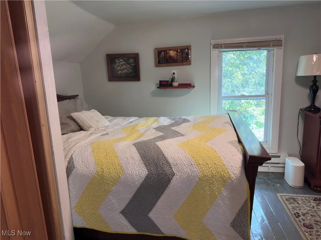 Bedroom with vaulted ceiling and hardwood / wood-style floors