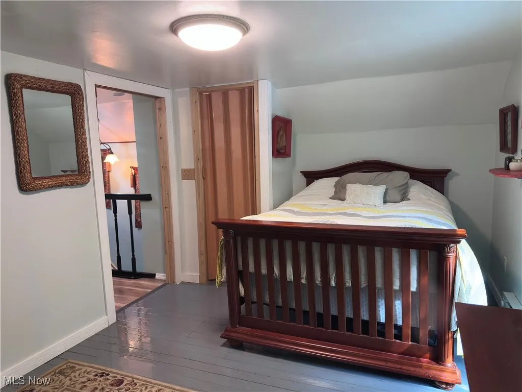 Bedroom featuring hardwood / wood-style floors and baseboards