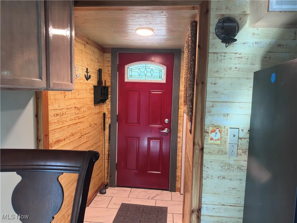 Entryway featuring wooden walls and wood ceiling