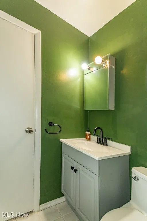 Half bath with vanity and tile patterned flooring