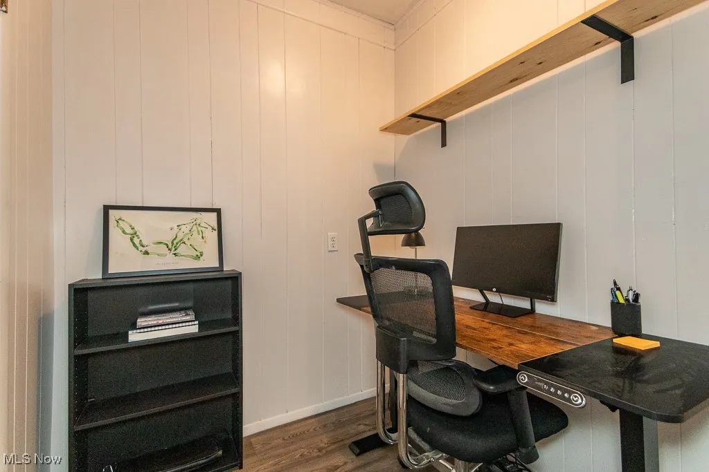 Home office with dark wood-style flooring and baseboards