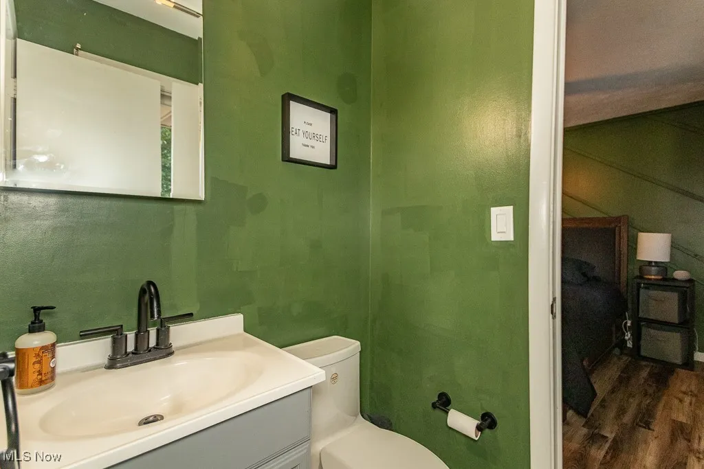 Half bath featuring vanity and wood finished floors