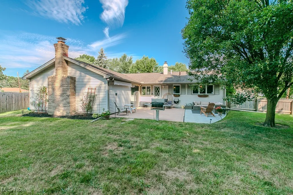Rear view of property with a chimney and a patio