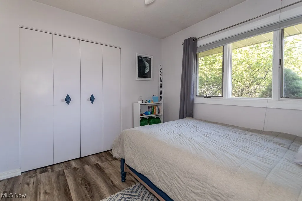 Bedroom with wood finished floors and a closet