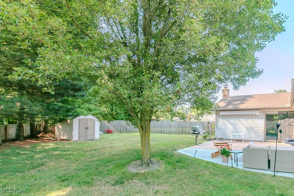 Fenced backyard featuring a patio and a storage shed