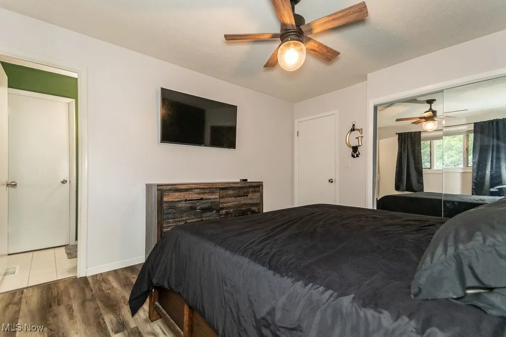 Bedroom with wood finished floors, a ceiling fan, and a closet