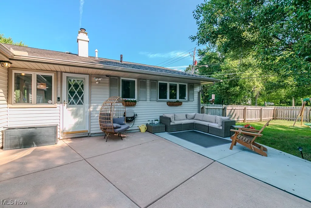 Rear view of property with outdoor lounge area, a chimney, a patio, and roof with shingles