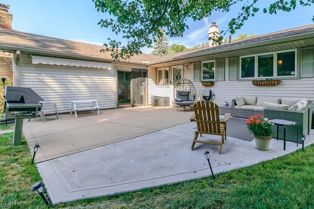 Back of house featuring a chimney, a patio area, and outdoor lounge area