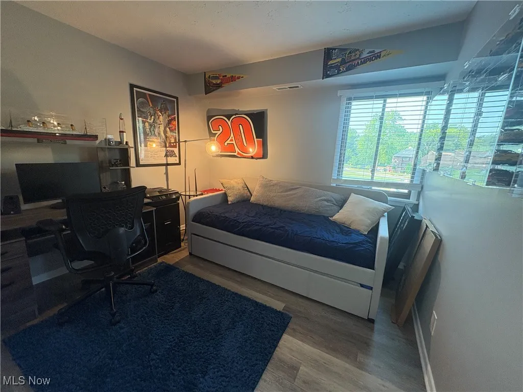Bedroom featuring wood finished floors and a desk
