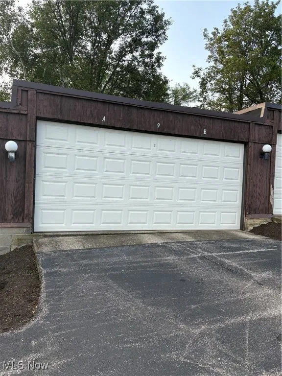Garage featuring asphalt driveway