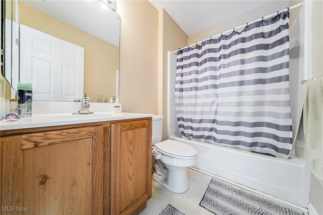 Full bath with vanity, shower / tub combo, and tile patterned floors