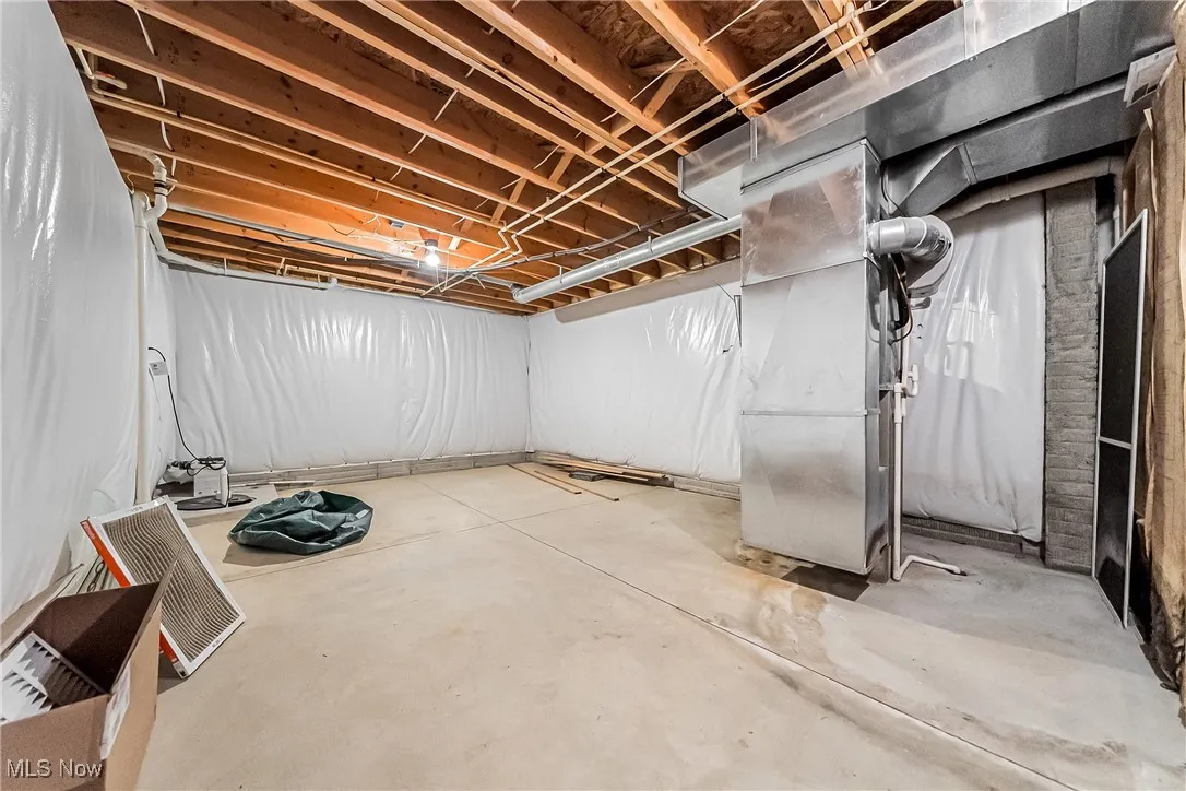 Unfinished below grade area featuring heating unit